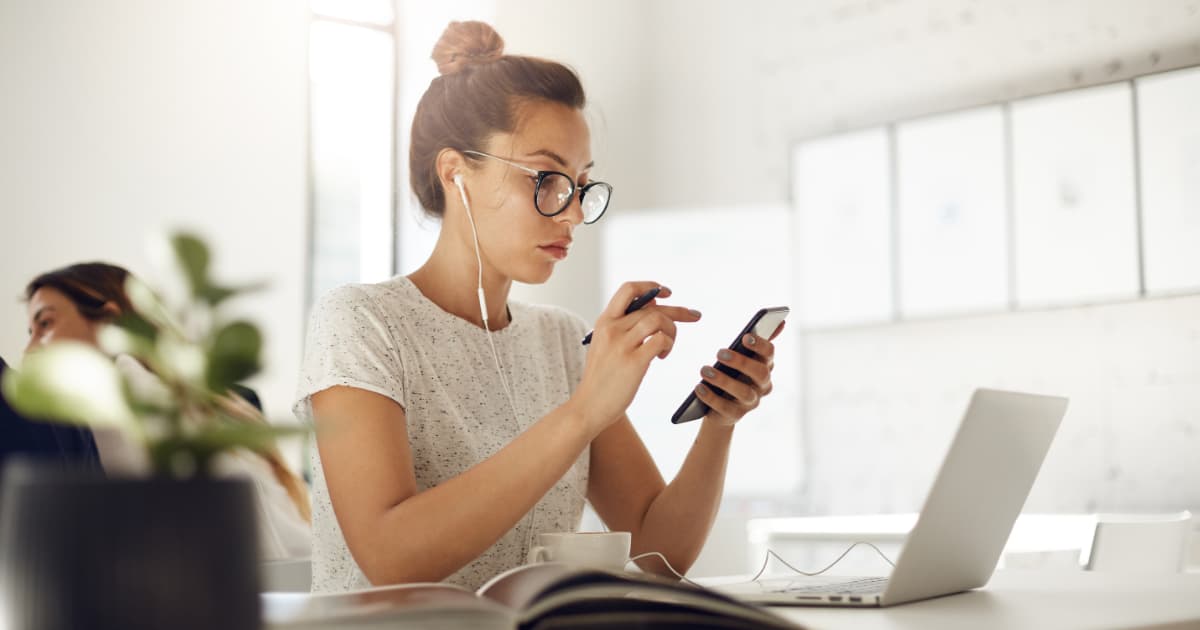 Profesional trabajando de forma remota revisando una lección breve en el celular durante una pausa de trabajo